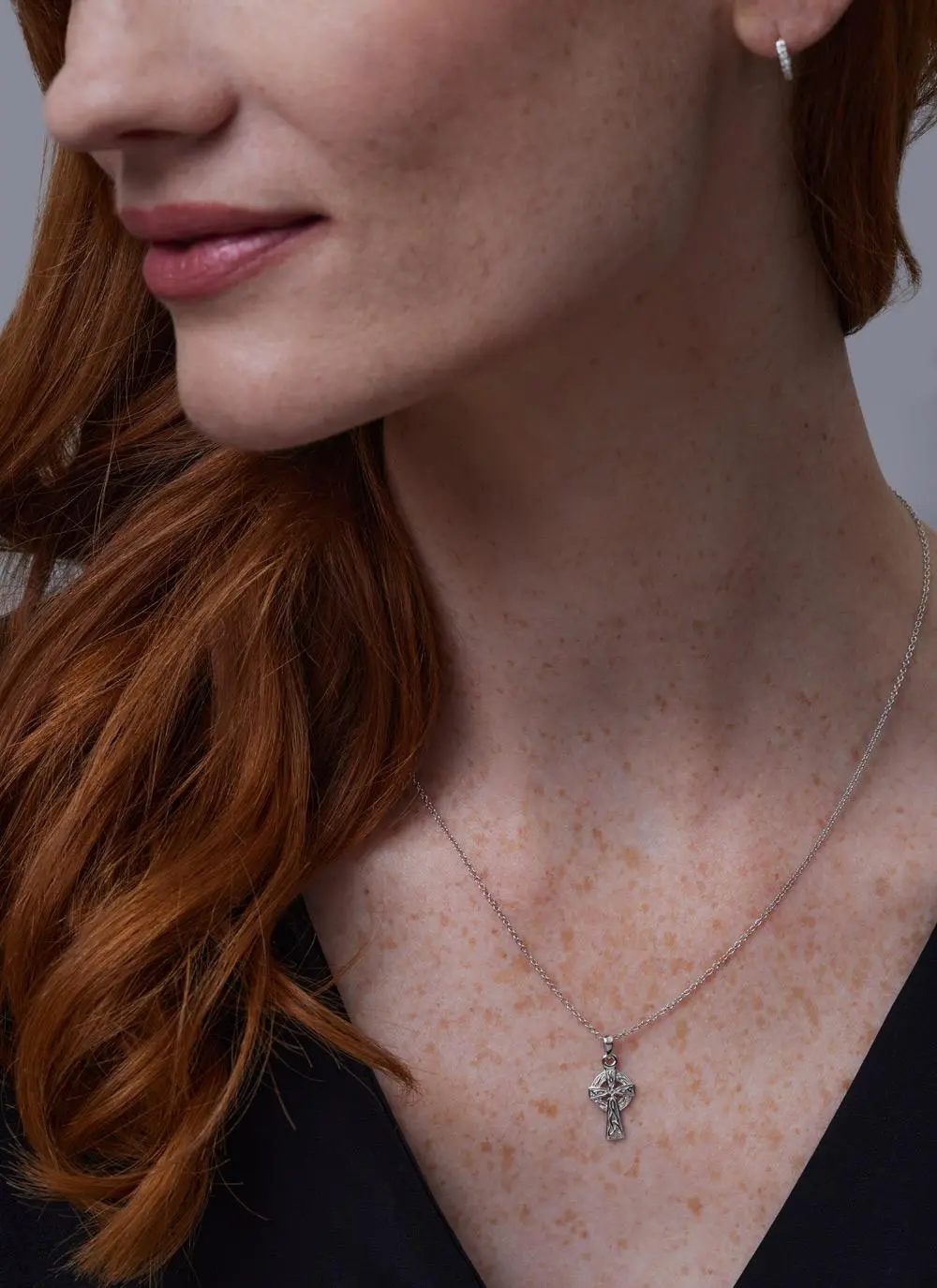 Close up shot of red haired model wearing Sterling Silver Small Celtic Cross Pendant